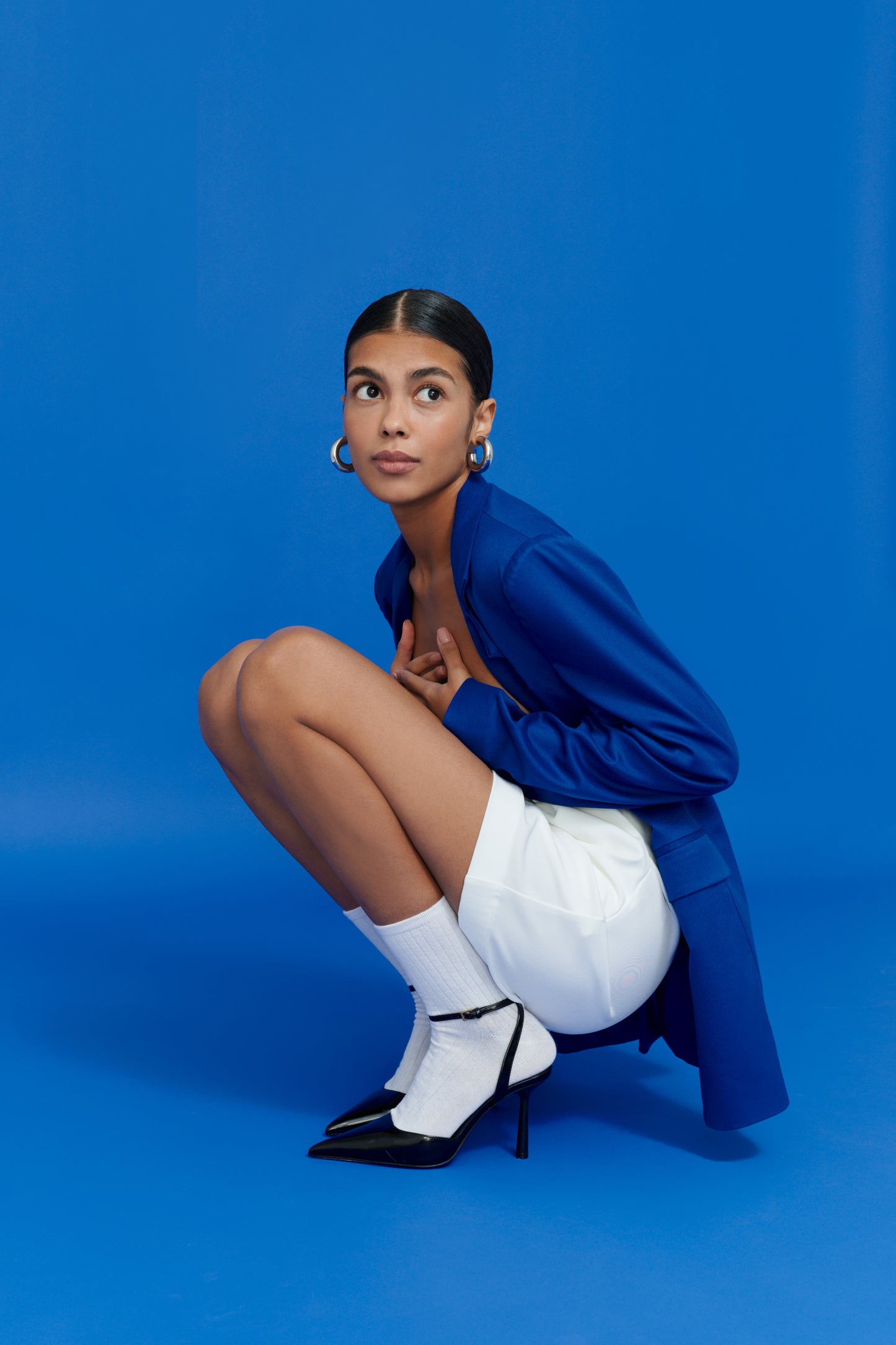 Fashion photo of white shorts styled with black heels and blue jacket