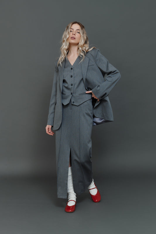 Model wearing gray skirt with matching blazer and vest, office look