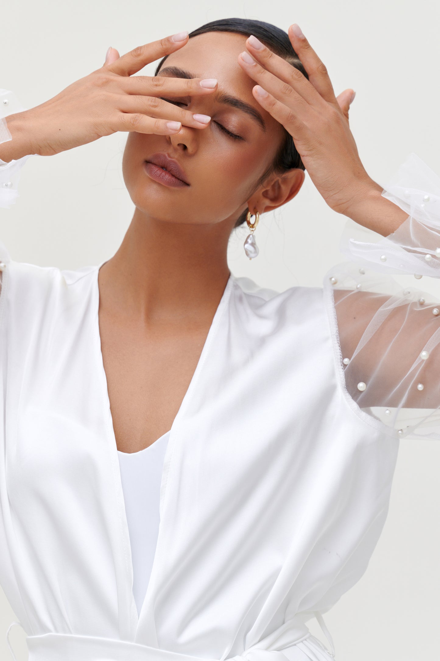 bride in white pearl bridal robe close up