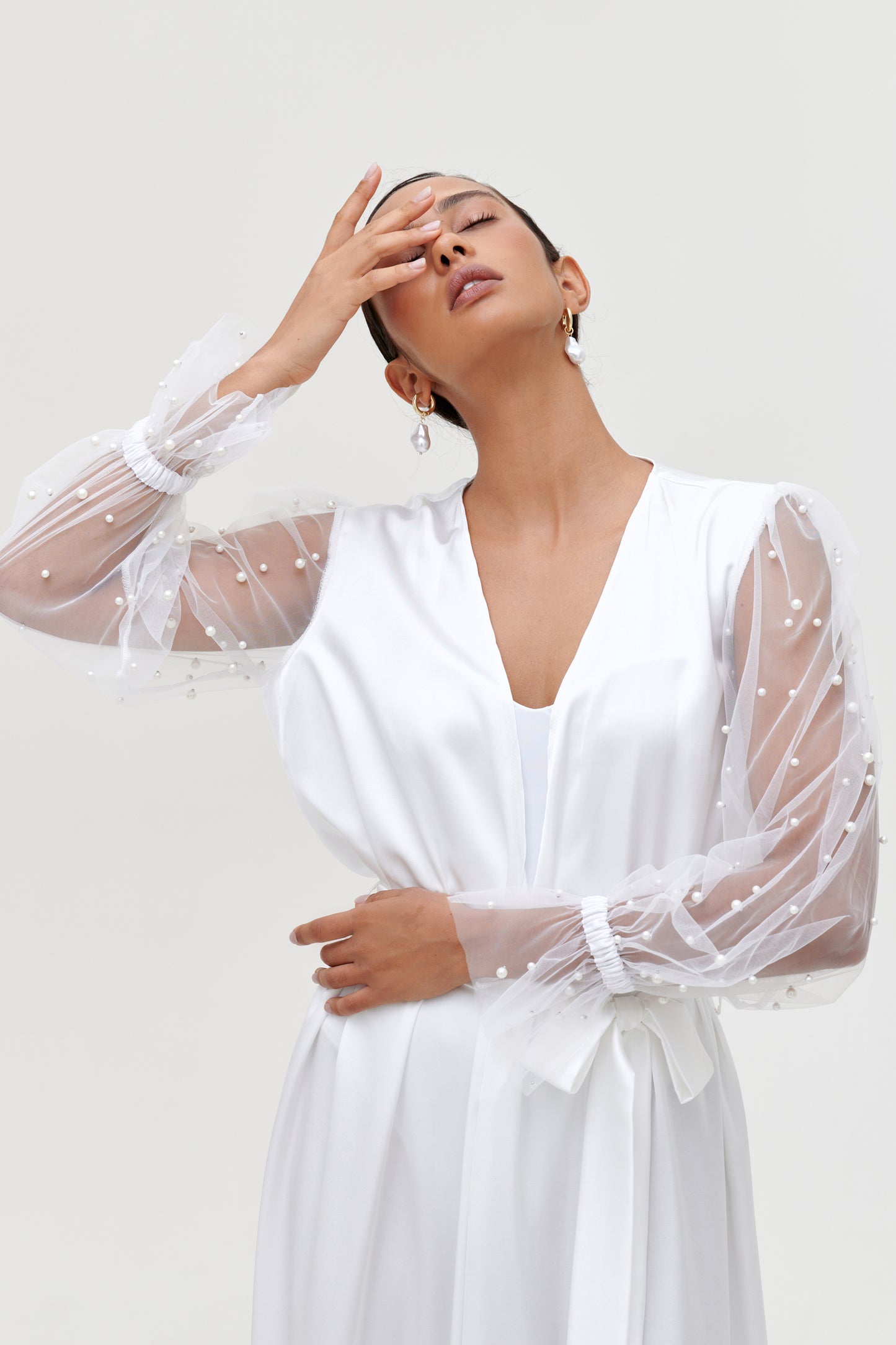 model wearing white pearl bridal robe with sheer pearl sleeves
